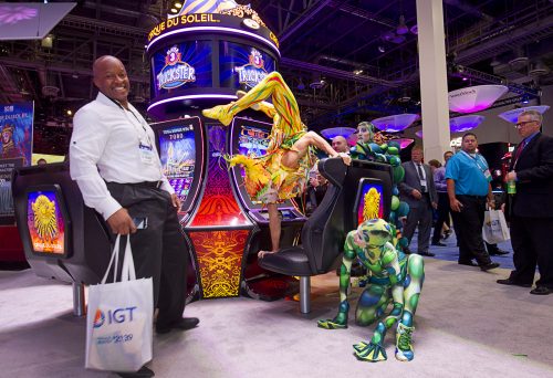 Shawn White moves out of the way as a Cirque du Soleil performer does a handstand on a Cirque du Soleil-themed slot machine during the Global Gaming Expo (G2E) at the Sands Expo Center Tuesday, Sept. 29, 2015.